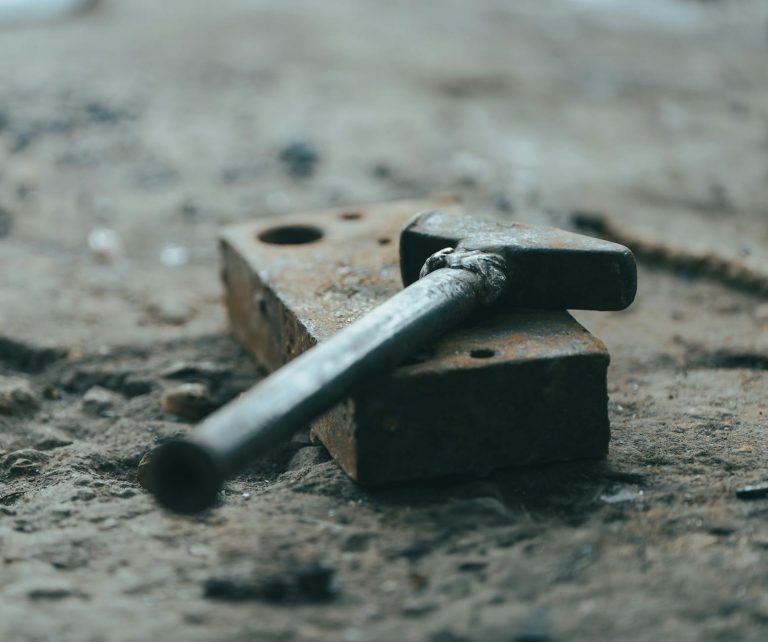 Altes Werkzeug entsorgen – rostiger Hammer auf verwitterter Werkbank