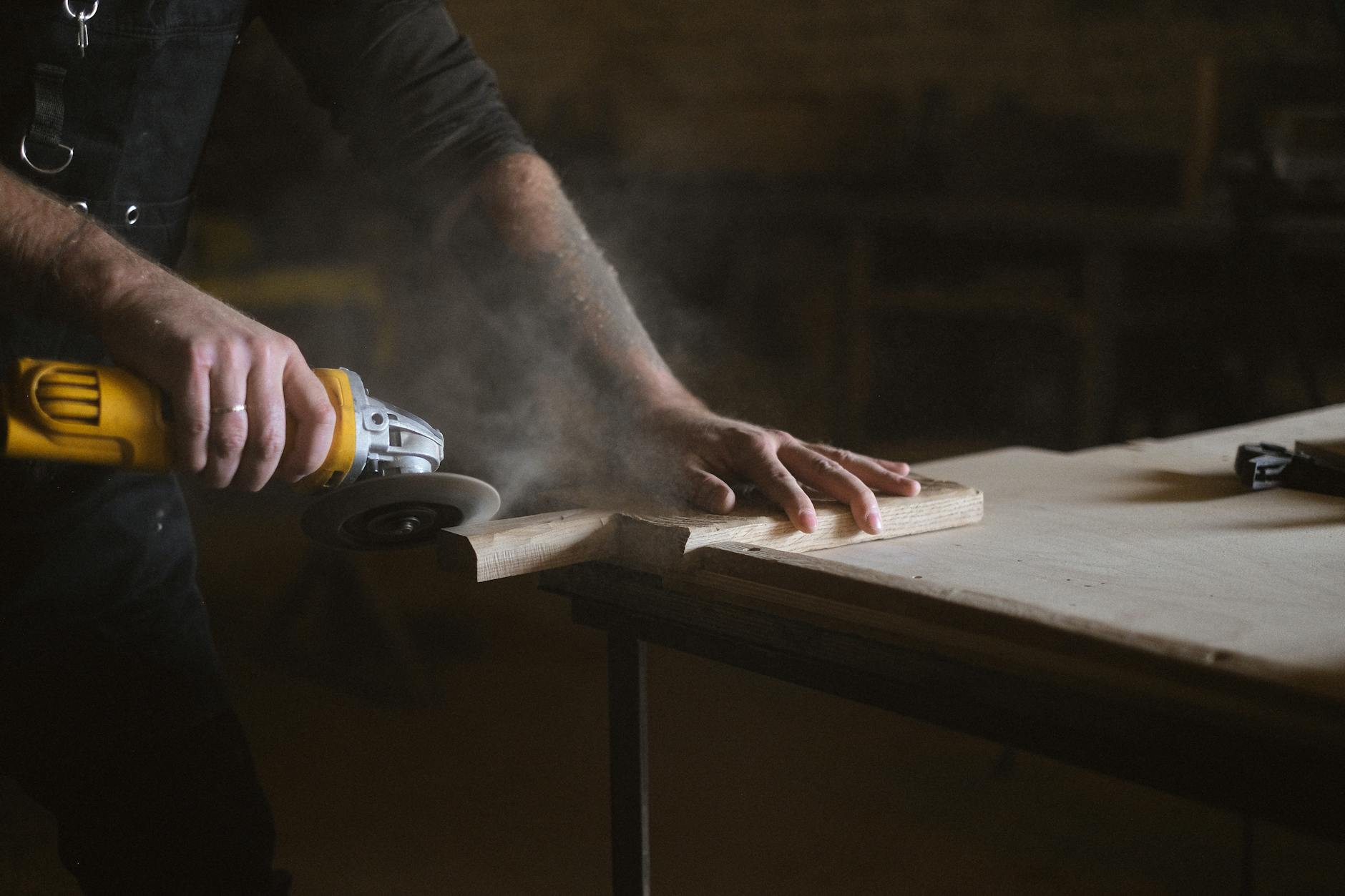 Werkzeuge mit B – Winkelschleifer beim Bearbeiten von Holz