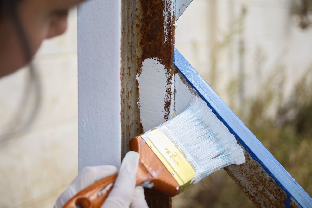 Drahtbürste beim Entfernen von Rost auf Metalloberfläche