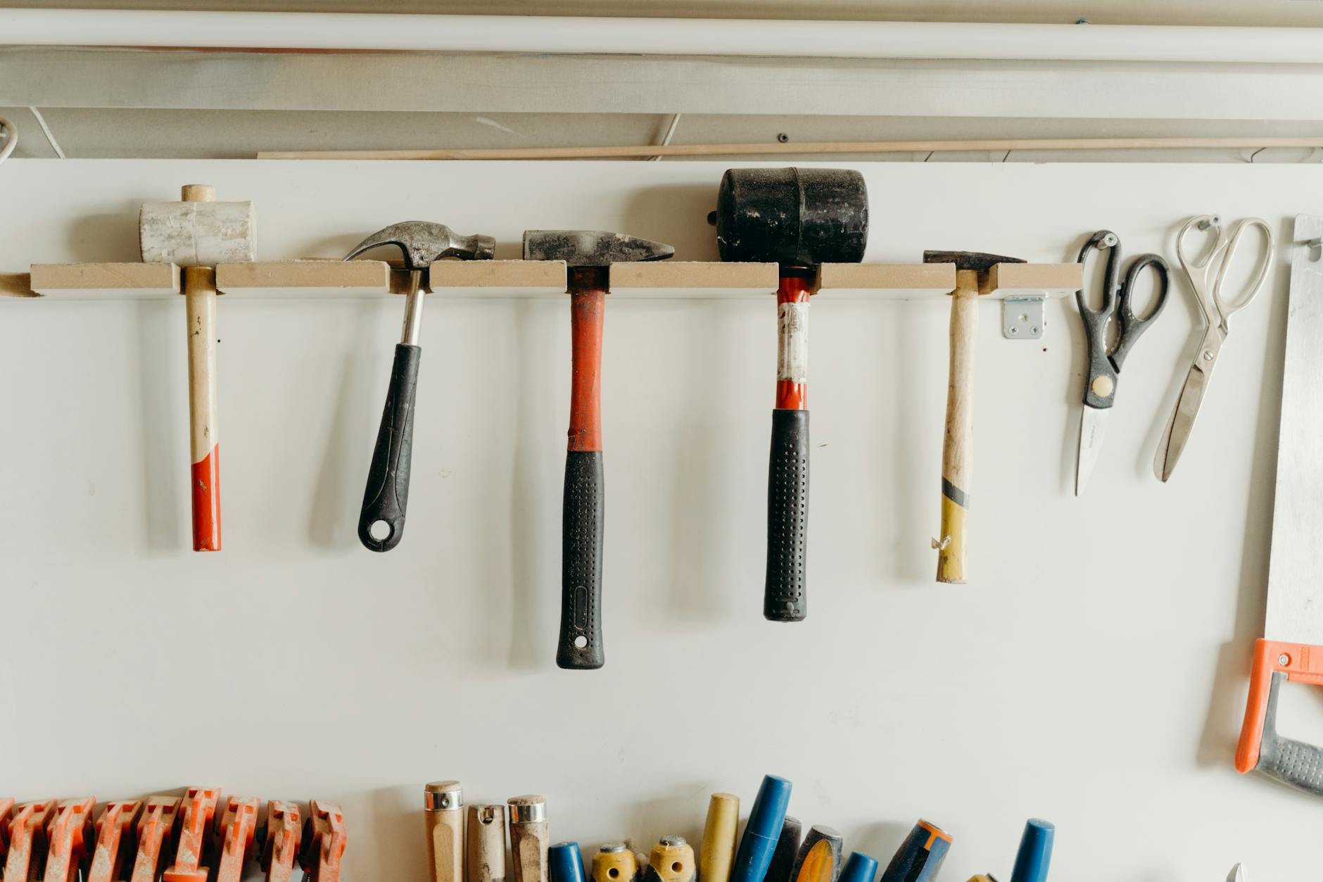 Werkzeuge mit G – verschiedene Handwerkzeuge an der Werkstattswand