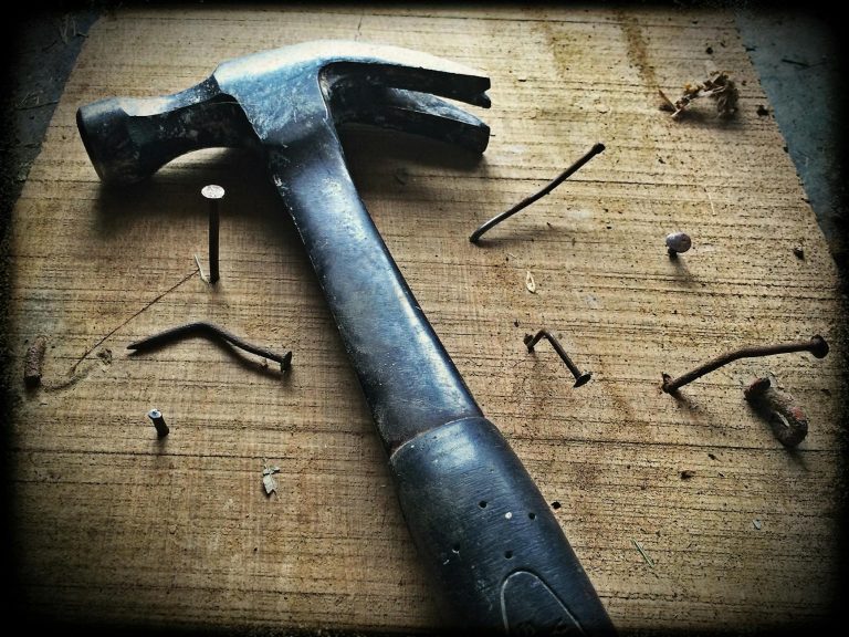 Werkzeuge mit H – Hammer auf Holzplank