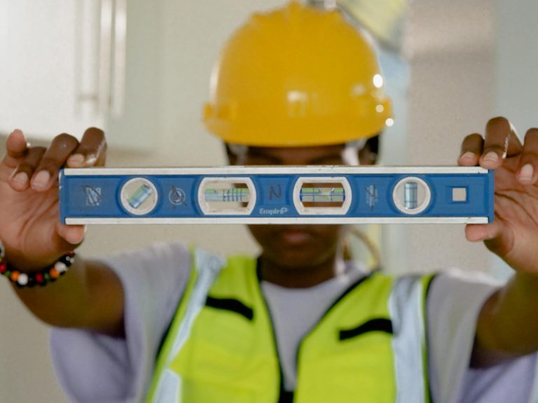 Werkzeuge mit W – Handwerker mit Wasserwaage bei der Arbeit