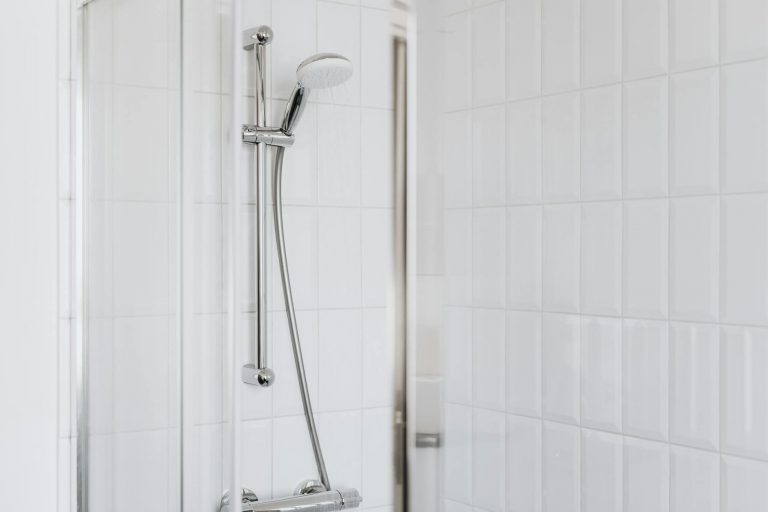 Duschstange abmontieren – verchromte Brausestange mit Wandhalterungen in der Dusche