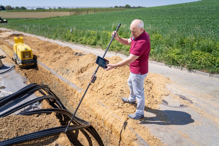 Erdkabel verlegen ohne Graben: Methoden, Vorschriften und Grenzen Erdkabel verlegen ohne Graben – Kabel in einer Trasse, Arbeiter prüft den Verlauf