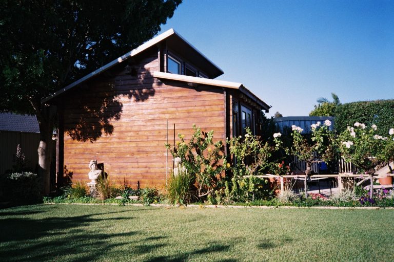 Gartenhaus selber bauen – fertiges Holz-Gartenhaus im gepflegten Garten