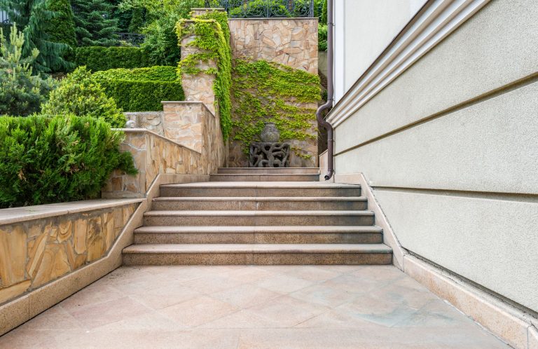 Außentreppe mit Flüssiggranit sanieren – Außentreppe aus Naturstein an einem Wohnhaus mit Bepflanzung