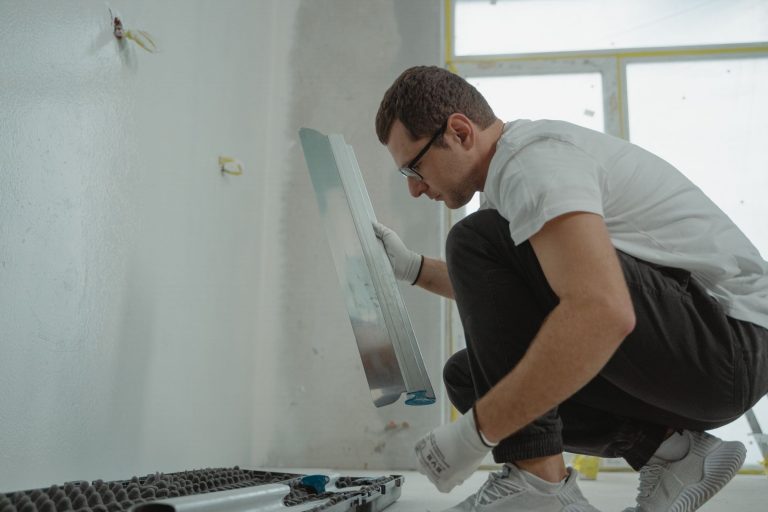 Schalungssteine verputzen: Aufbau, Anleitung und Tipps Schalungssteine verputzen – Handwerker zieht Putz mit der Glättkelle an einer Wand ab