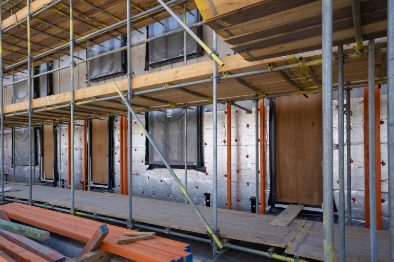 Styroporplatten streichen: Welche Farbe wirklich funktioniert Styroporplatten streichen – gedämmte Fassade mit Styropor-Dämmplatten am Gerüst
