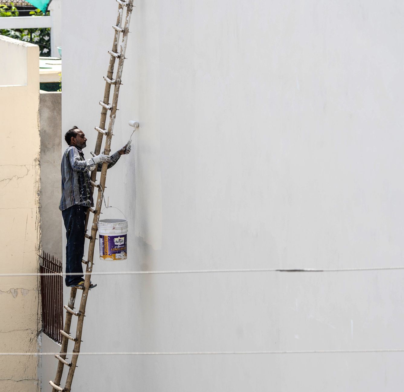 Styropor streichen – Fassade wird mit einer Rolle und wasserbasierter Farbe gestrichen
