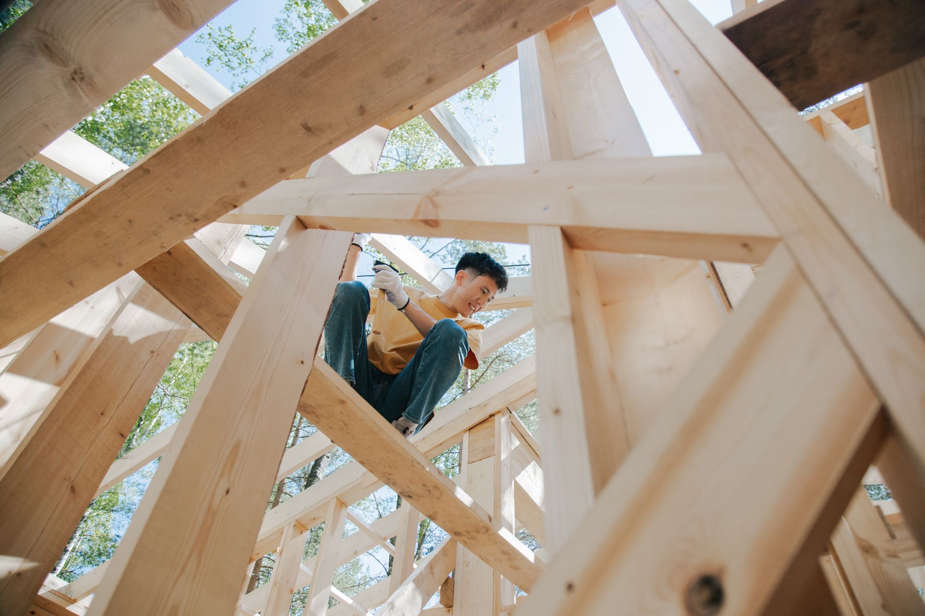 Traglast Holzbalken – Zimmerer arbeitet an einer Holzbalken-Konstruktion