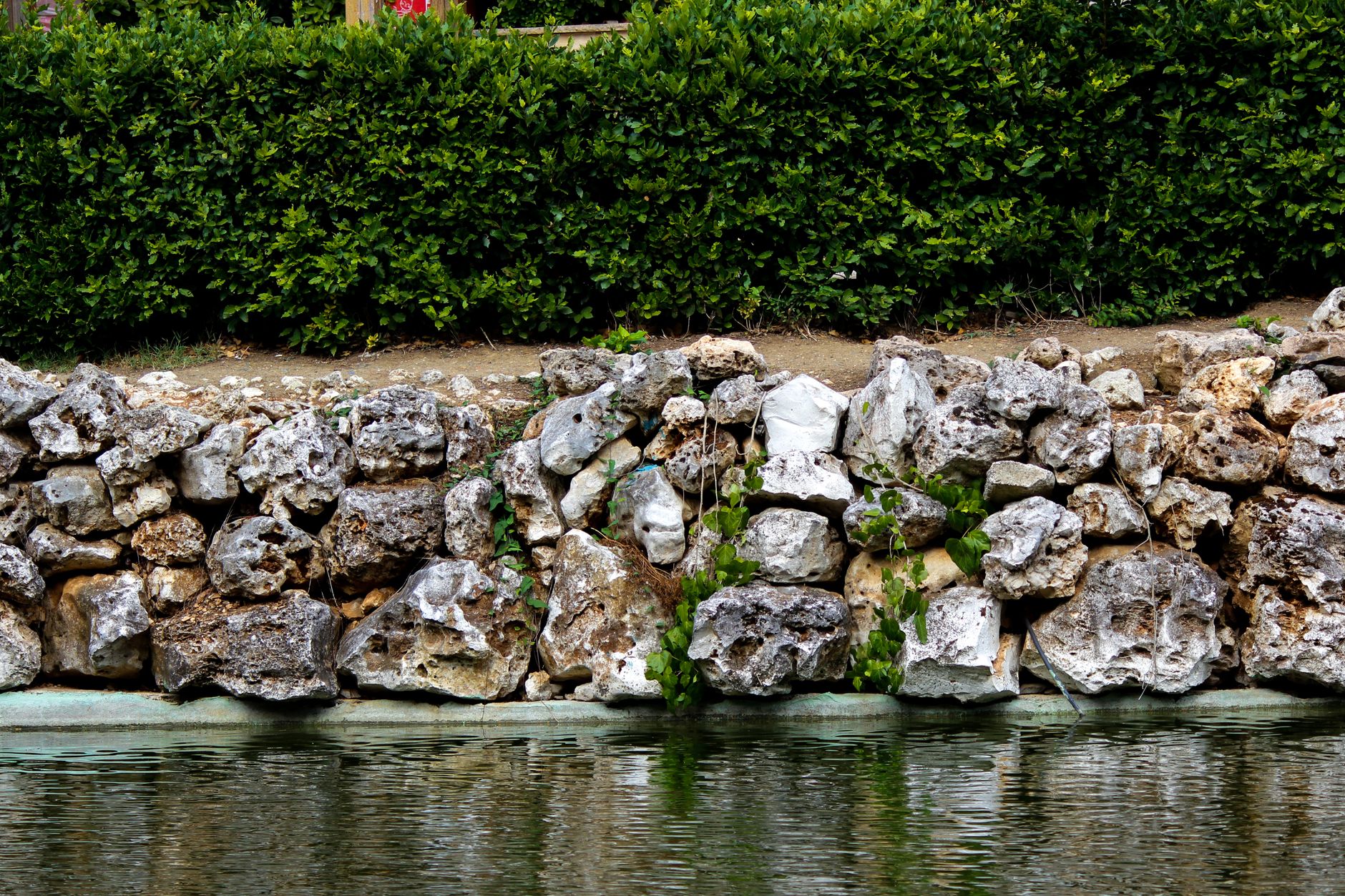 Trockenmauer ohne Fundament – Natursteinmauer im Garten mit begrünter Umgebung