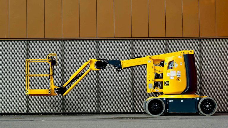 A yellow articulated boom lift parked outdoors