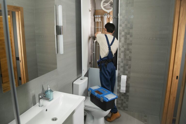 Wasserleitung 16 oder 20 mm – Installateur arbeitet am geöffneten Installationsschacht im Bad